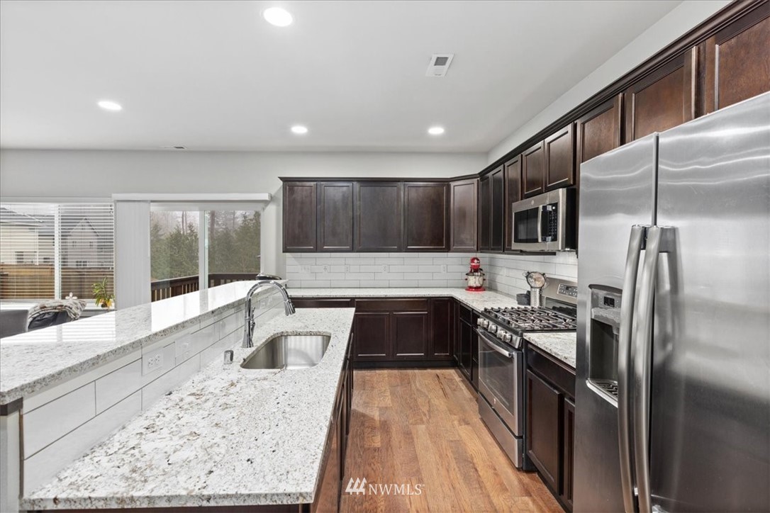 15817 Meridian Avenue South, Unit 38 Bothell, WA 98012 - Photo 8 of 35 a large kitchen with kitchen island a large window and stainless steel appliances