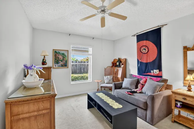 a living room with patio furniture and a potted plant