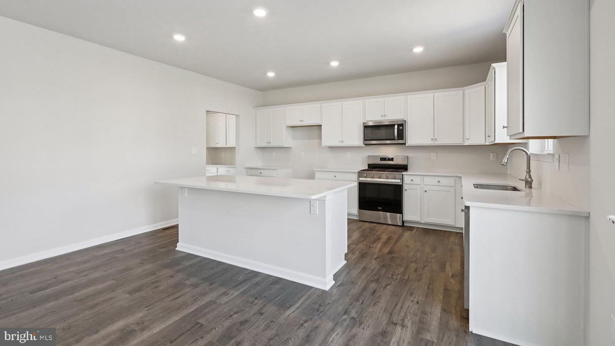 120 Winding Road Easton, PA 18040 - Photo 24 of 80 a kitchen with wooden floors white cabinets and stainless steel appliances