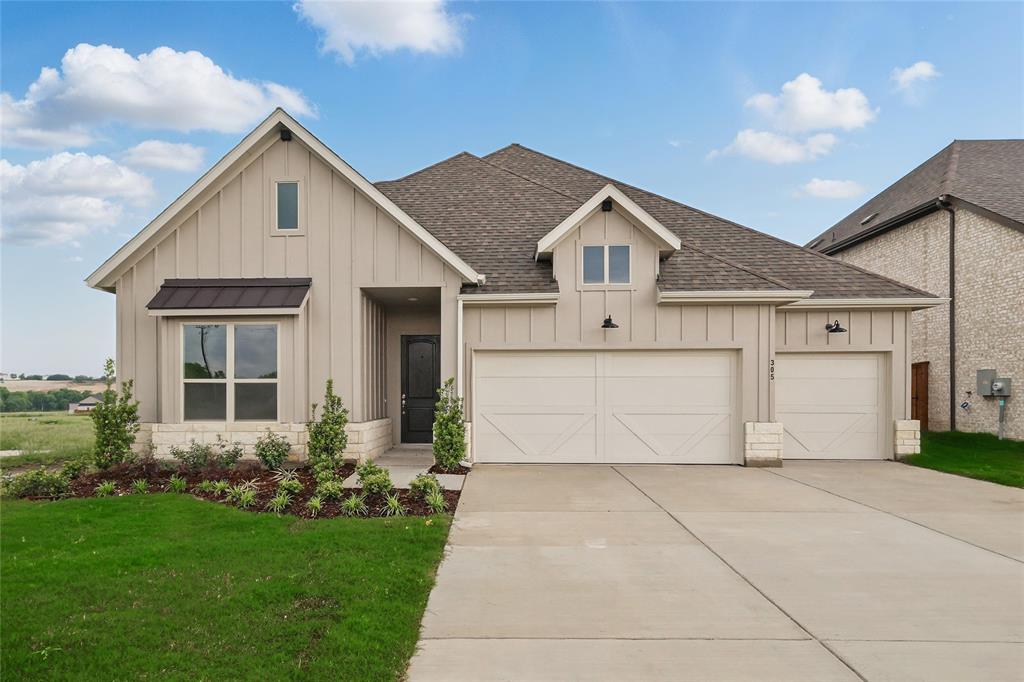 View of front of property with board and batten siding, roof with shingles, concrete driveway, a garage, and a front yard