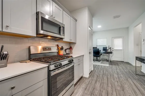 a kitchen with stainless steel appliances a stove microwave and cabinets