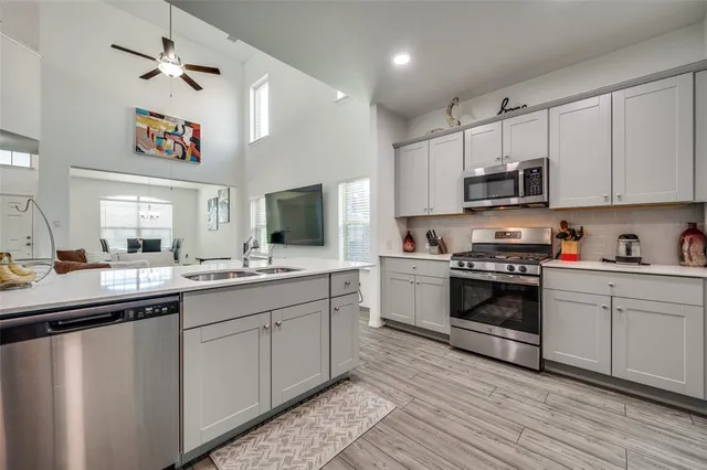 a kitchen with kitchen island granite countertop a sink cabinets and stainless steel appliances