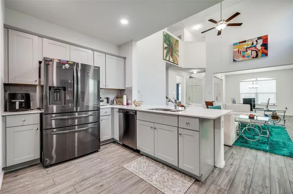 a kitchen with kitchen island a counter top space a sink stainless steel appliances and cabinets