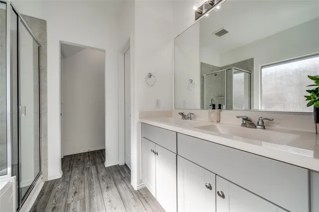 a bathroom with a double vanity sink and mirror