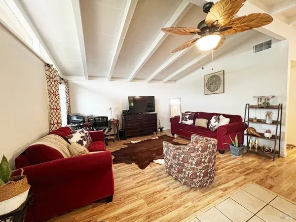 a living room with furniture a flat screen tv and a table