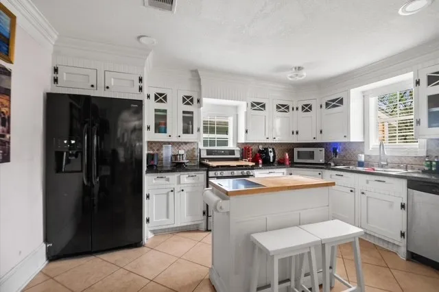 a kitchen with stainless steel appliances granite countertop a refrigerator and a stove top oven