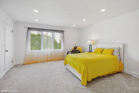 a bedroom with a bed and a large window