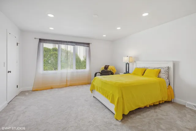 a bedroom with a bed and a large window