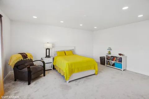 a spacious bedroom with a bed and a chandelier