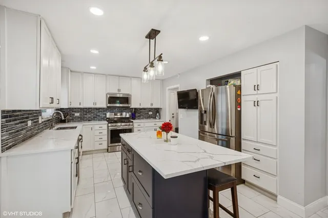 a kitchen that has a lot of cabinets and refrigerator in it