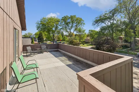 a view of roof deck with furniture and trees