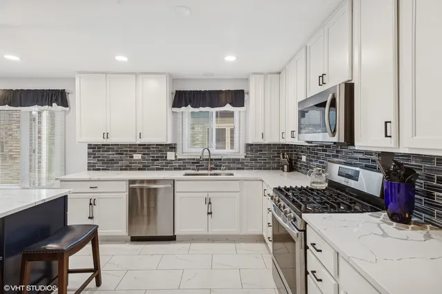 a kitchen with kitchen island granite countertop a stove sink and cabinets