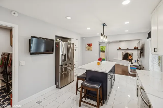a kitchen with kitchen island a refrigerator stove and microwave with wooden floor