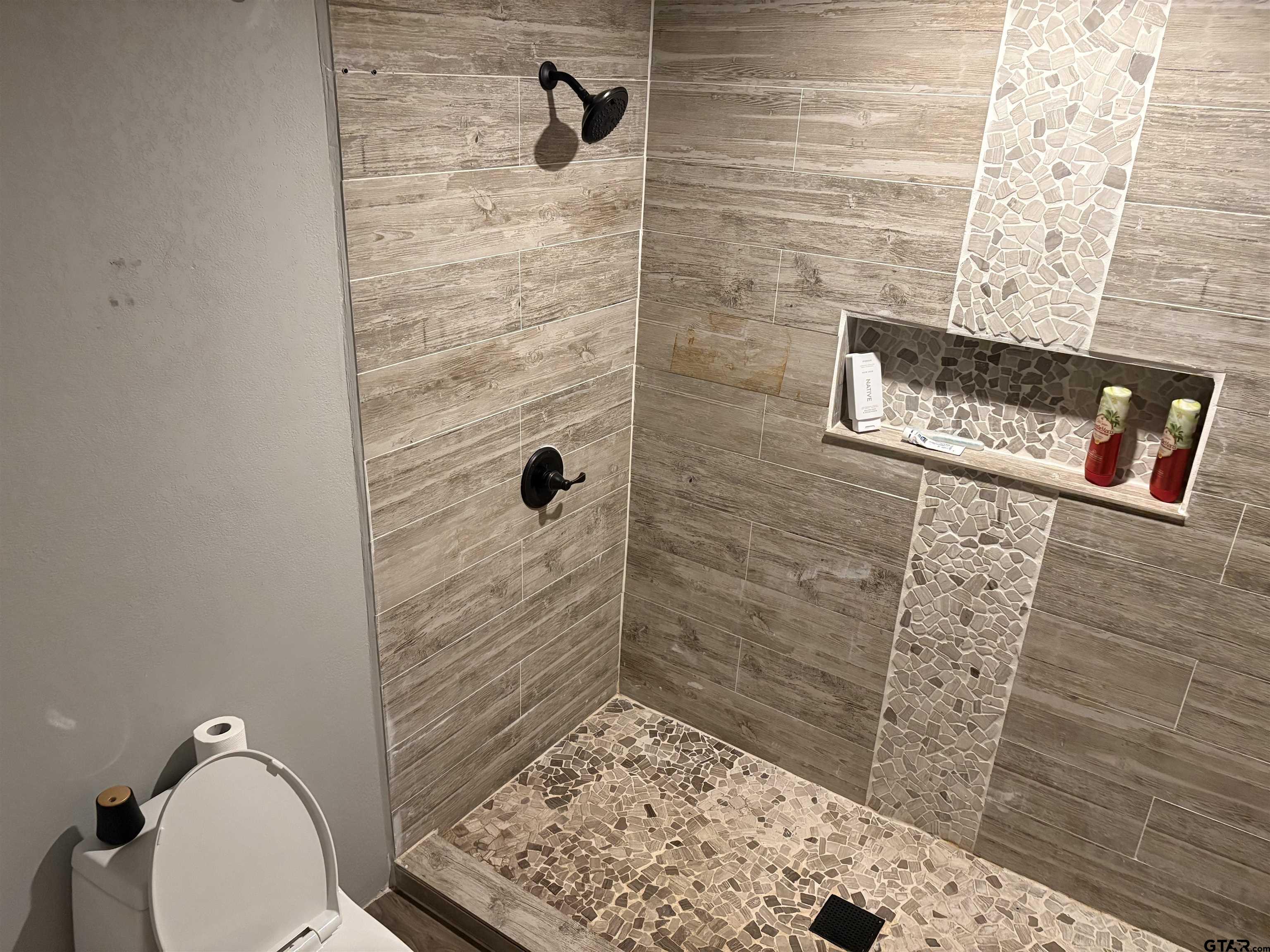 705 North Edwards Avenue Mount Pleasant, TX 75455 - Photo 35 of 36 a bathroom with a toilet and a shower