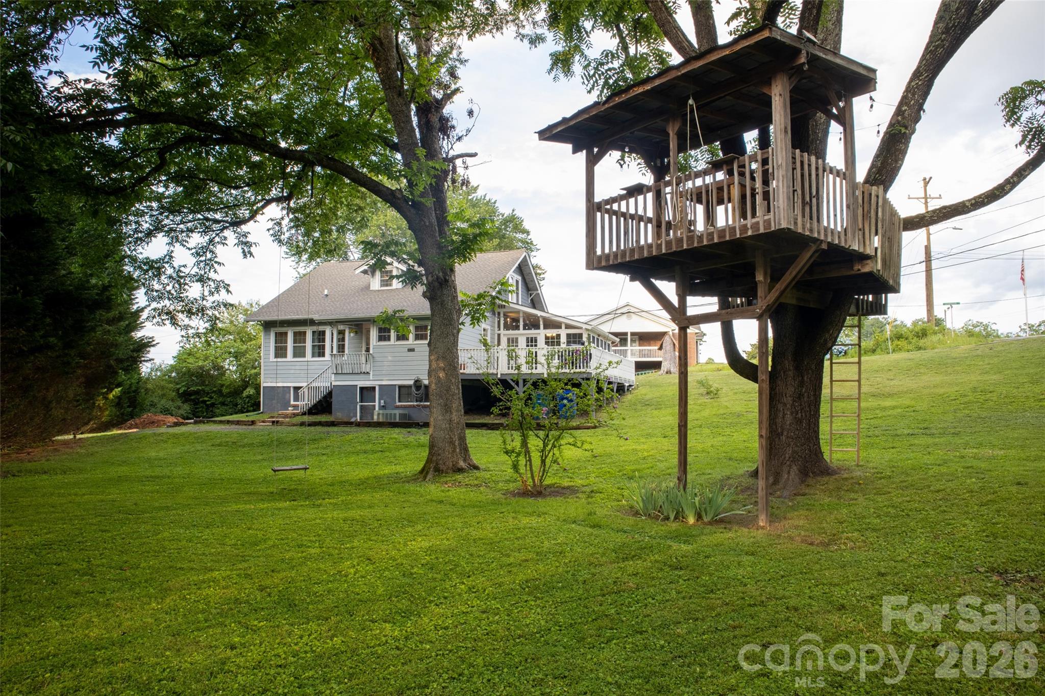 a view of a big yard with a table and chairs under an umbrella