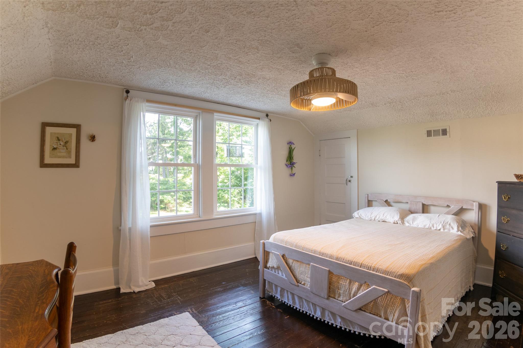 102 Cuthberson Street Morganton, NC 28655 - Photo 30 of 45 a spacious bedroom with a bed and a chandelier
