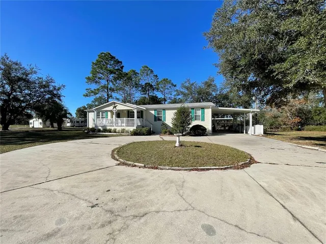 a front view of a house with a yard and trees