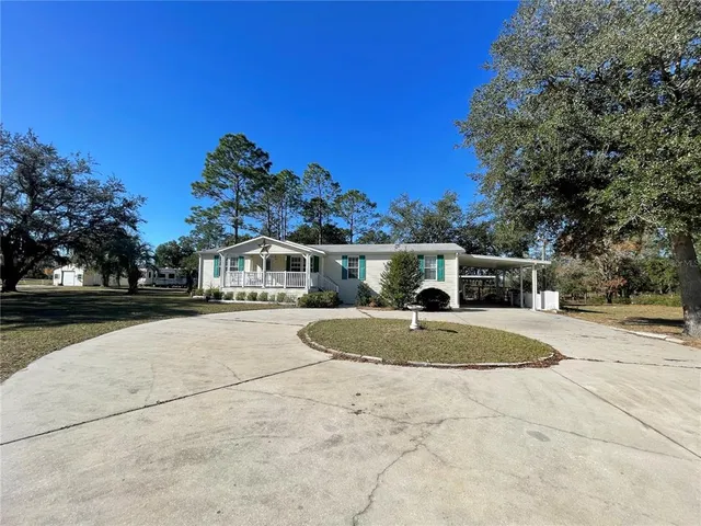 a front view of a house with a yard and trees
