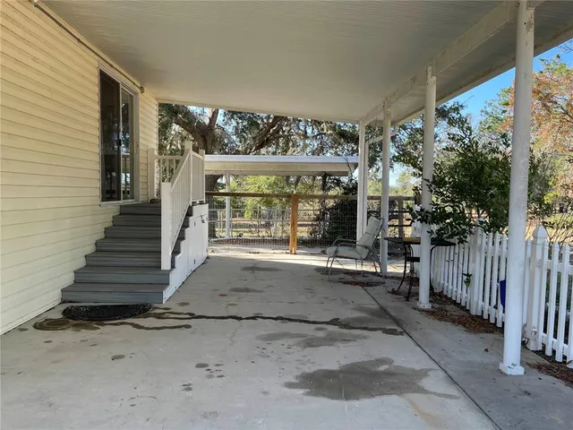 an empty room with wooden floor cabinet and windows