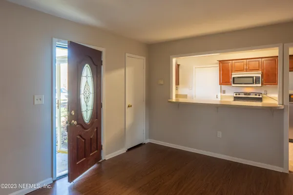 an empty room with wooden floor and a window