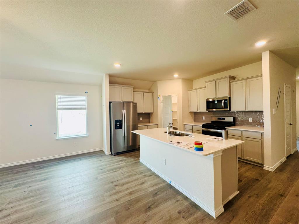 4028 Moss Road Pilot Point, TX 76258 - Photo 5 of 29 a kitchen with stainless steel appliances a refrigerator sink and microwave