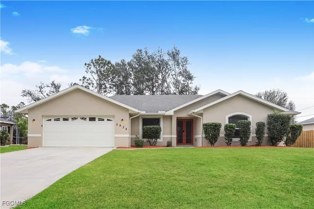 a front view of a house with a garden and yard