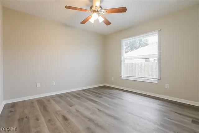 an empty room with a window and a fan