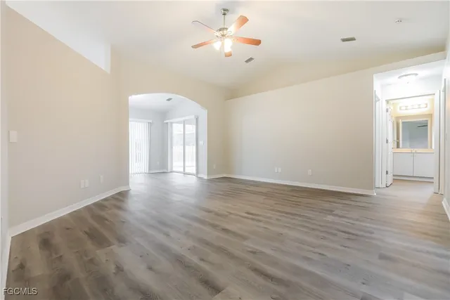 a view of a room with wooden floor and a ceiling fan