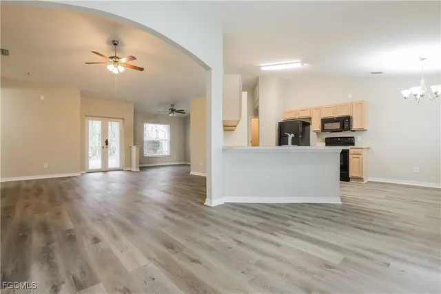a view of a big room with wooden floor and kitchen