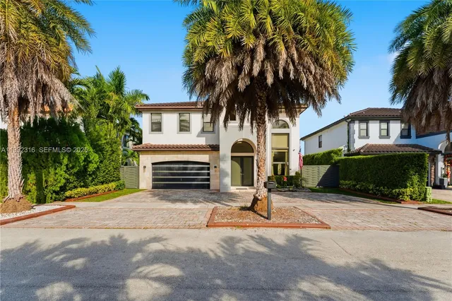 a view of a house with a yard and large trees