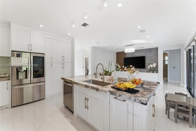 a kitchen with stainless steel appliances kitchen island granite countertop a sink and cabinets