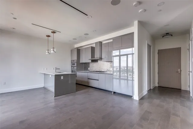 a large white kitchen with a stove a sink a microwave and cabinets