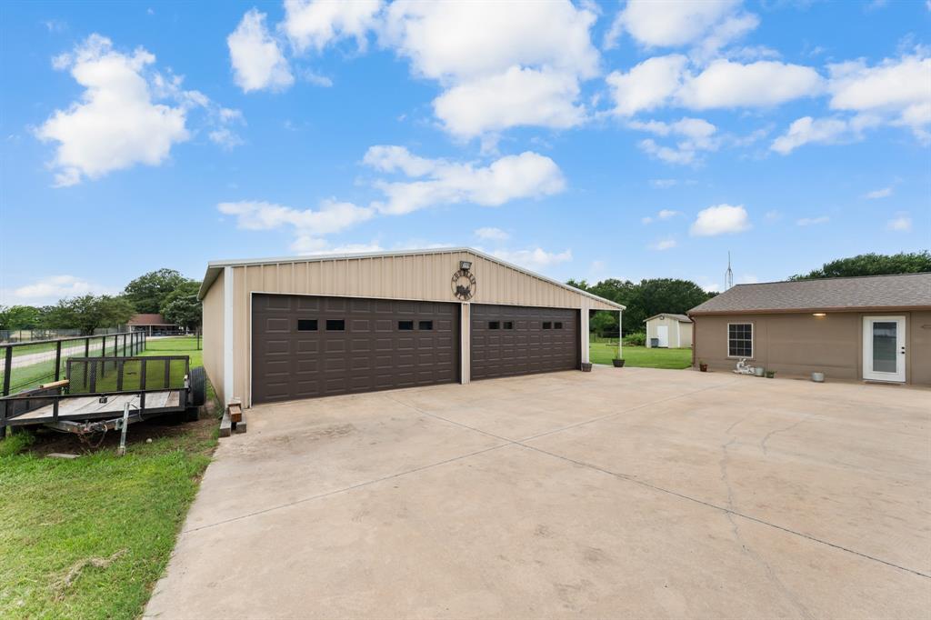 380 Farr Altom Road Seagoville, TX 75159 - Photo 20 of 30 Large detached metal structure featuring two broad garage doors with window inserts and a concrete drive
