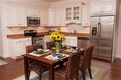 89 Lewis Bay Road, Unit 202 Hyannis, MA 02601 - Photo 2 of 5 a kitchen with a refrigerator a stove a microwave a dining table and chairs