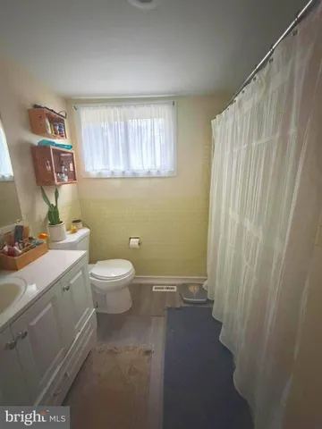 a bathroom with a granite countertop sink a toilet and a shower