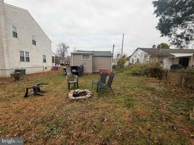 a view of a backyard with chairs and iron fence