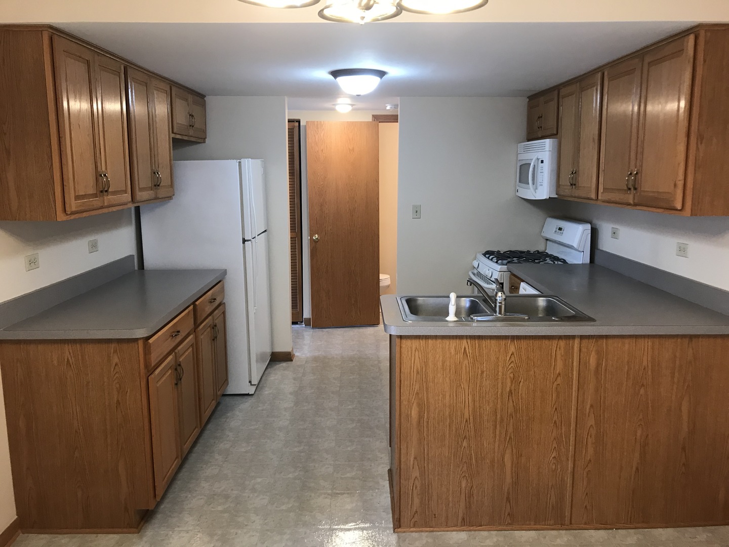1456 Berta Drive Crest Hill, IL 60403 - Photo 6 of 17 a kitchen with kitchen island granite countertop wooden cabinets and sink
