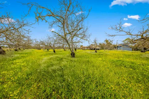 a view of house with backyard and outdoor seating
