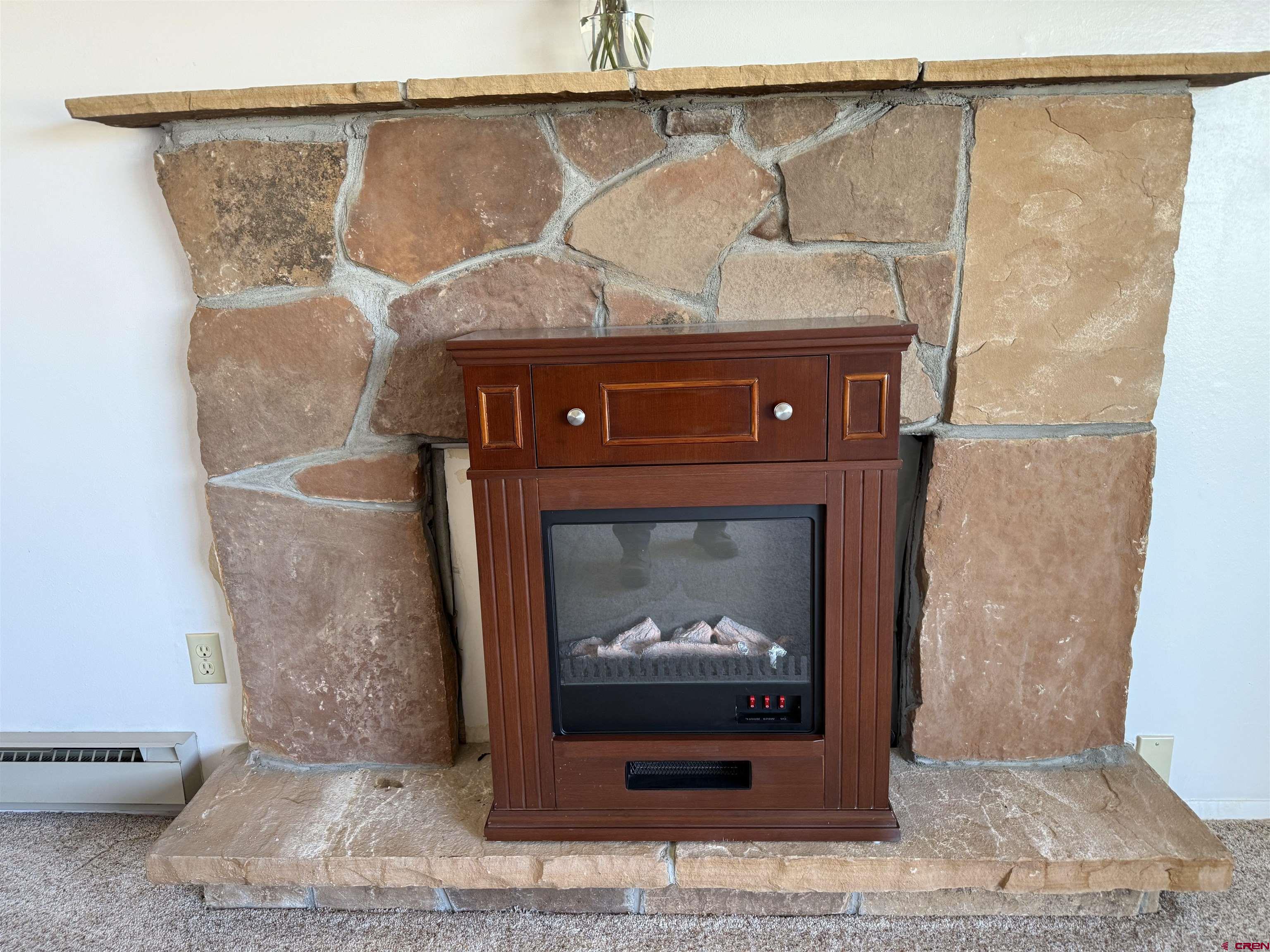 1793 Roundup Road Delta, CO 81416 - Photo 26 of 41 a fireplace with a clock on top of it