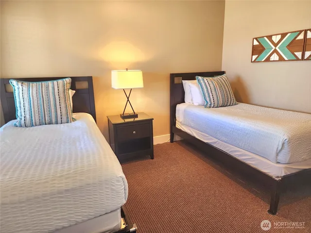 a spacious bedroom with a bed and lamp