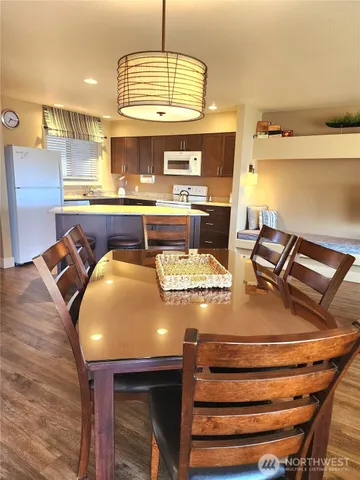 a view of a kitchen with stainless steel appliances granite countertop a stove and white cabinets