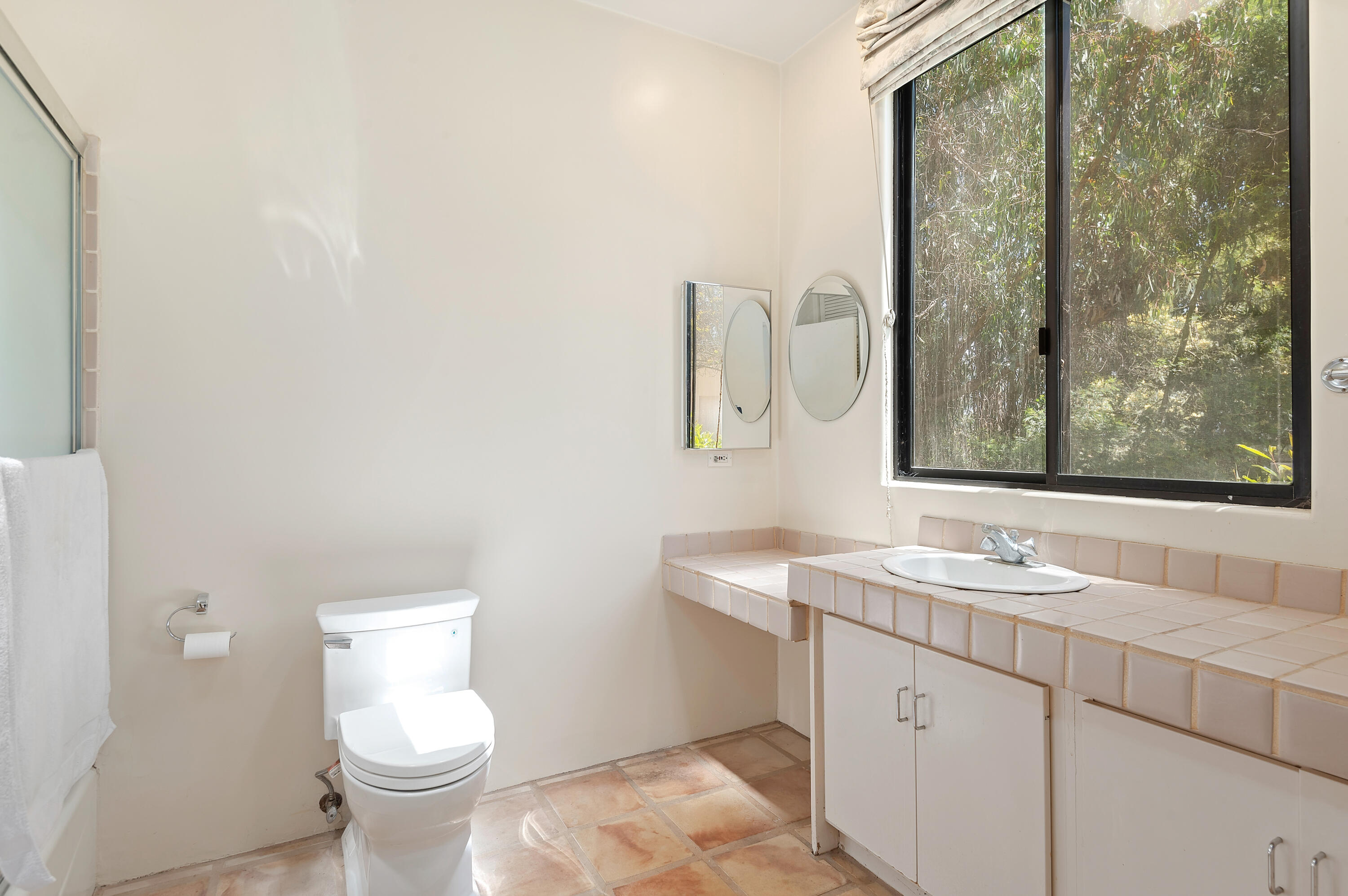 1181 Glenview Road Santa Barbara, CA 93108 - Photo 36 of 46 a bathroom with a granite countertop sink a toilet and a mirror