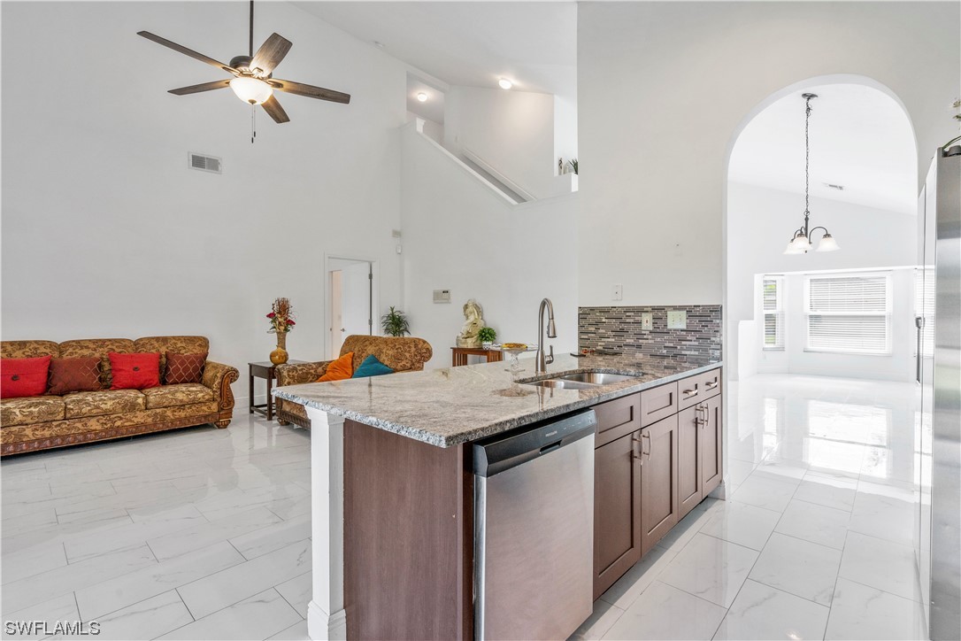 21660 Windham Run Estero, FL 33928 - Photo 16 of 32 a kitchen with stainless steel appliances granite countertop a sink a stove and a refrigerator