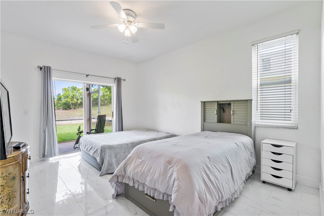 21660 Windham Run Estero, FL 33928 - Photo 19 of 32 a bedroom with a bed and a flat tv screen on dresser