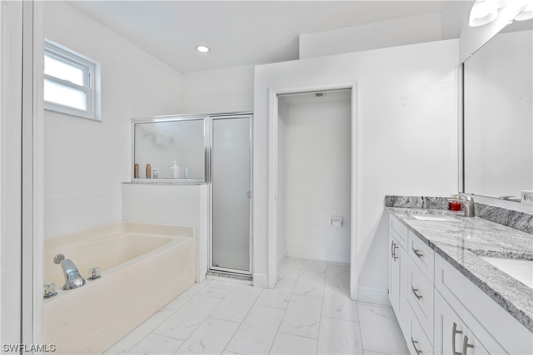 21660 Windham Run Estero, FL 33928 - Photo 21 of 32 a spacious bathroom with a tub sink and mirror