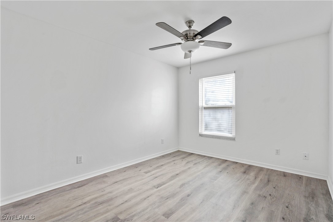 21660 Windham Run Estero, FL 33928 - Photo 26 of 32 an empty room with wooden floor and windows