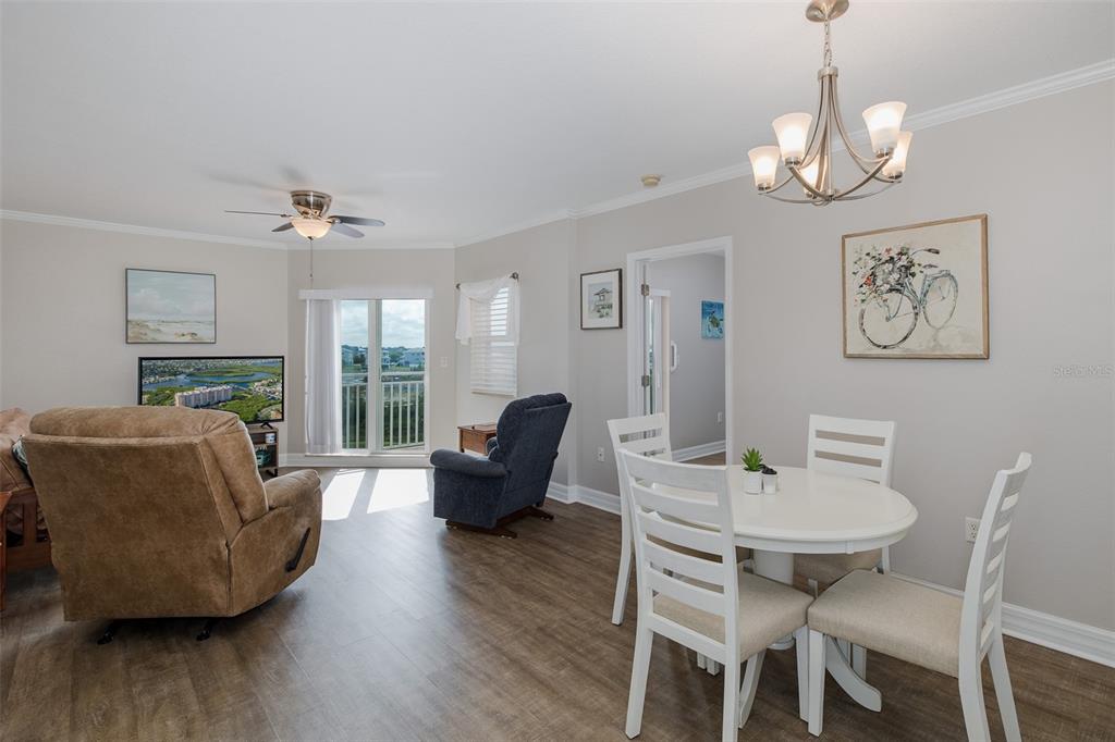 4516 Seagull Drive, Unit 411 New Port Richey, FL 34652 - Photo 17 of 47 a view of a dining room with furniture wooden floor and a chandelier