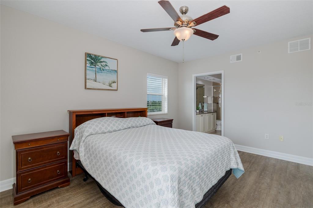 4516 Seagull Drive, Unit 411 New Port Richey, FL 34652 - Photo 21 of 47 a bedroom with a bed and a chandelier
