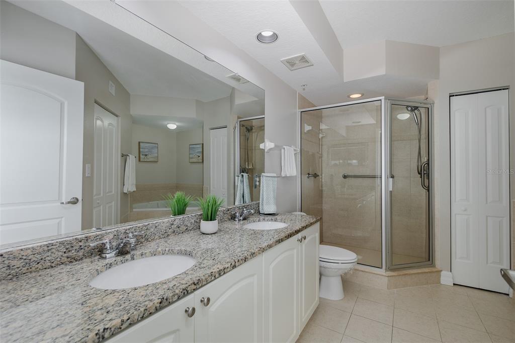 4516 Seagull Drive, Unit 411 New Port Richey, FL 34652 - Photo 22 of 47 a bathroom with a granite countertop sink a toilet and shower