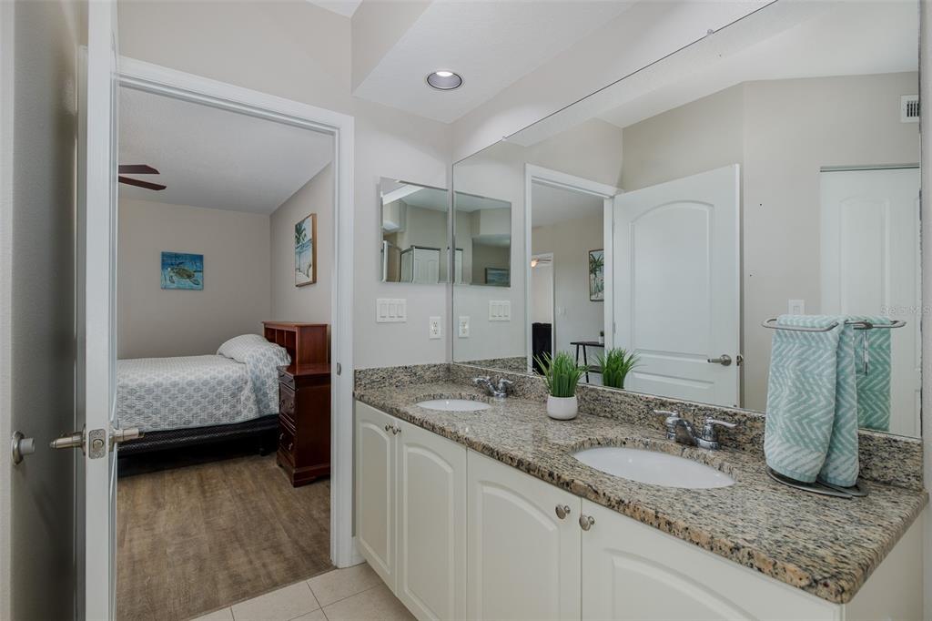 4516 Seagull Drive, Unit 411 New Port Richey, FL 34652 - Photo 24 of 47 a en suite bathroom with a granite countertop sink and a mirror
